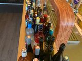 bottles of alcohol are lined up on a counter in a bar