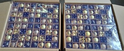deux boîtes remplies de décorations de Noël posées sur une table