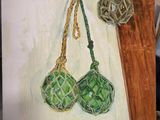 painting of two green balls hanging from a rope on a canvas