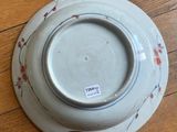 a white plate with red flowers on it on a wooden table