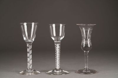 three clear wine glasses sitting on top of a table next to each other