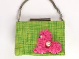 sac à main vert et rose orné d'une fleur rose sur le devant
