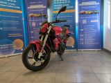 une moto rouge garée devant une banderole bleue et blanche