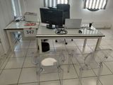 un bureau en verre sur lequel est posé un ordinateur