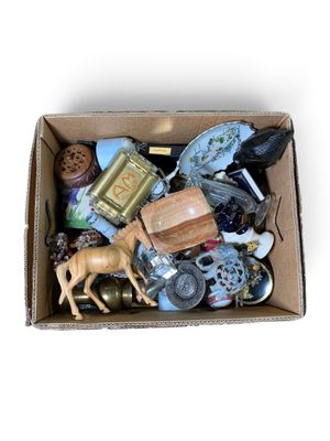 une boîte en carton remplie d'objets divers posée sur une surface blanche
