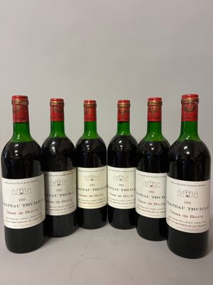 six bouteilles de vin sont alignées sur une table