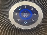 an air purifier sitting on top of a bed next to a pillow