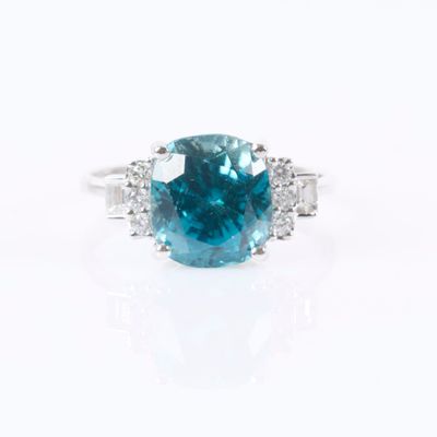 a blue diamond and diamond ring on a white background