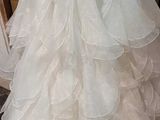 a white wedding dress hanging on a rack in a room
