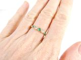 an image of a woman ' s hand with a green and white ring on it