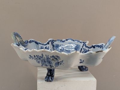 un bol bleu et blanc posé sur un socle, orné d'un oiseau
