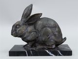 statue of a rabbit on a marble base on a white background