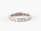 un gros plan d'une bague « éternité » sertie de diamants sur fond blanc