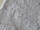 un gros plan d'une couverture tricotée blanche posée sur une table
