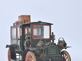 a small model of an old fashioned car on a white surface