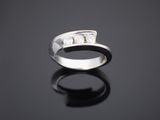 gros plan d'une bague en argent sur une surface noire