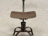 an old wooden chair sitting on top of a metal base