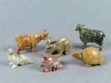cinq petites figurines d'animaux posées sur une surface grise