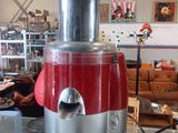 un mixeur rouge et argent posé sur une table