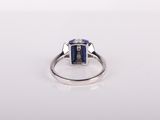 a blue sapphire and diamond ring on a white surface