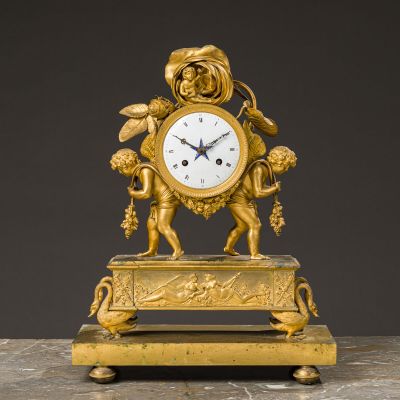 an image of a gold clock with cherensils on a marble base