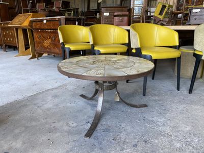 plusieurs chaises et une table dans une pièce où l'on aperçoit de nombreux meubles à l'arrière-plan