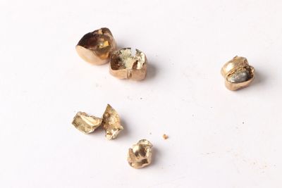 several pieces of gold are arranged on a white surface