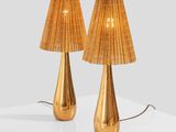 two gold lamps on a white table with a white background