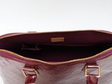 the inside of a purple purse with a gold zipper