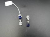 une paire de boucles d'oreilles en saphir et diamant posées sur un fond noir