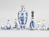 several blue and white vases are arranged in a row on a gray surface