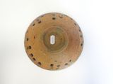 a brown bowl with holes on it on a white surface