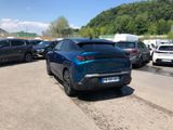 a blue car parked in a parking lot next to other cars