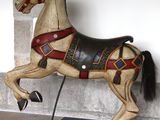 a wooden horse that is standing on a black and white checkered floor