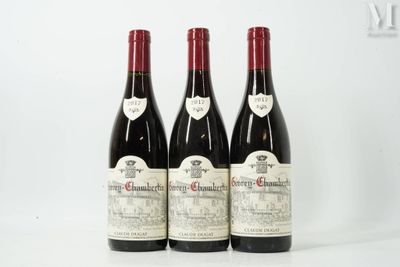 trois bouteilles de vin rouge posées sur une table blanche