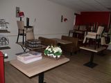 a room with tables, chairs, and a vase of flowers on the table