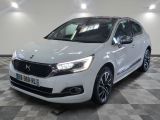 une voiture blanche est garée dans une grande pièce au sol en damier