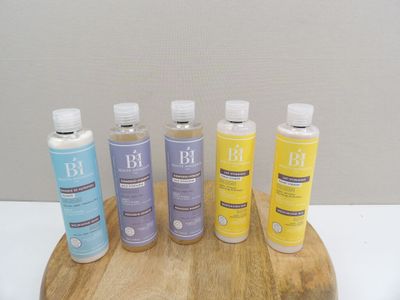 five bottles of lotion sitting on a wooden stand