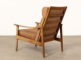 the chair is made of wood and has a brown cushion