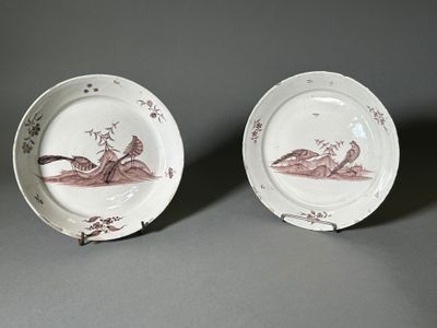 deux assiettes avec des oiseaux peints dessus, posées sur une table