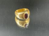 a close up of a gold ring with two red stones
