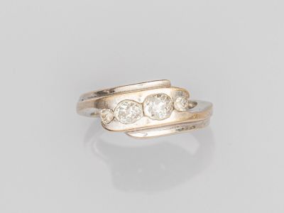 une bague en or sertie de trois diamants sur fond blanc