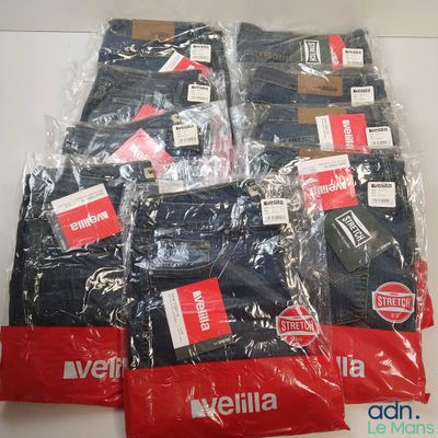 plusieurs paires de jeans pour homme, emballées dans des sacs en plastique, posées sur une table