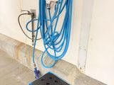 a blue hose on the ground next to a blue box