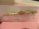 someone is holding a card with a picture of a pink bead on it
