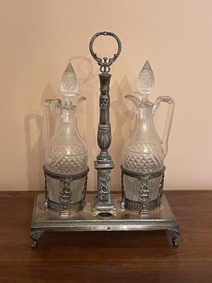 three glass vases and a metal stand on a table