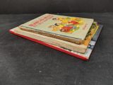 three children ' s books stacked on top of each other on a table