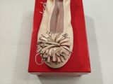 quelqu'un porte une paire de chaussures qui se trouvent sur une boîte rouge