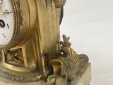 a gold clock sitting on top of a white table