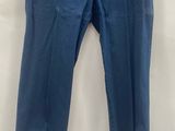 a blue pants hanging on a hanger on a white wall
